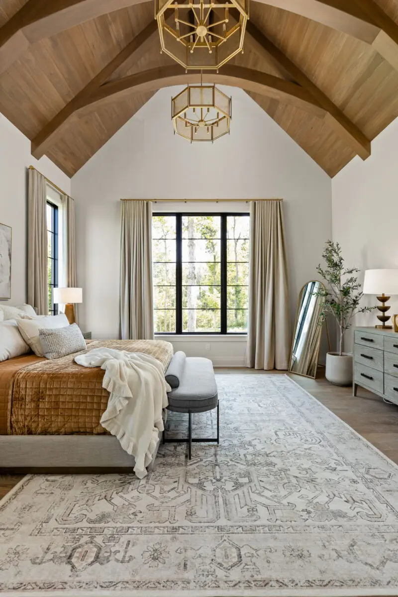 Primary bedroom with a vaulted wood ceiling, a brass lantern chandelier and long drapes