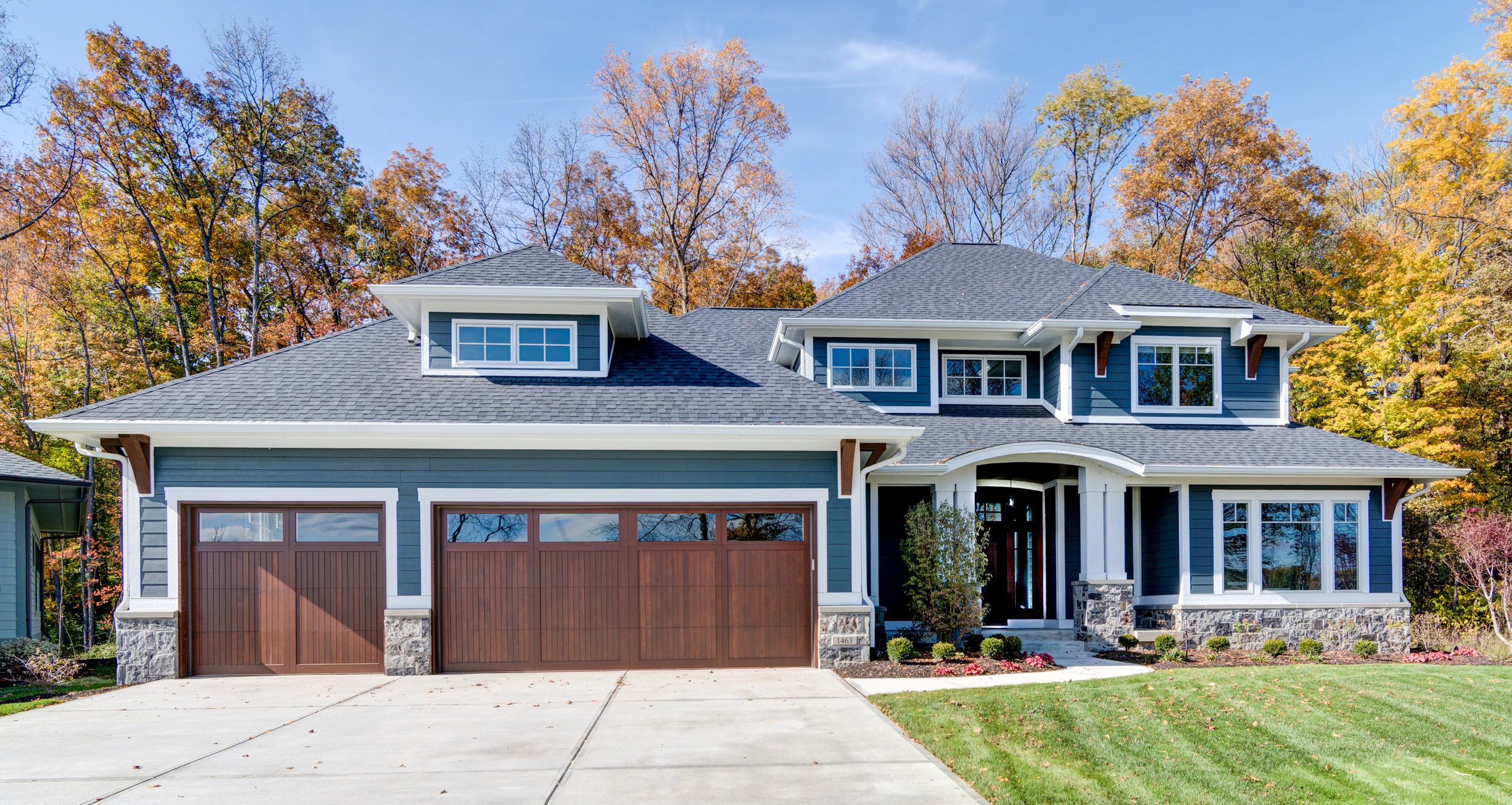 A custom home with a stunning blue garage door, built by a leading custom home builder in Carmel and Westfield.