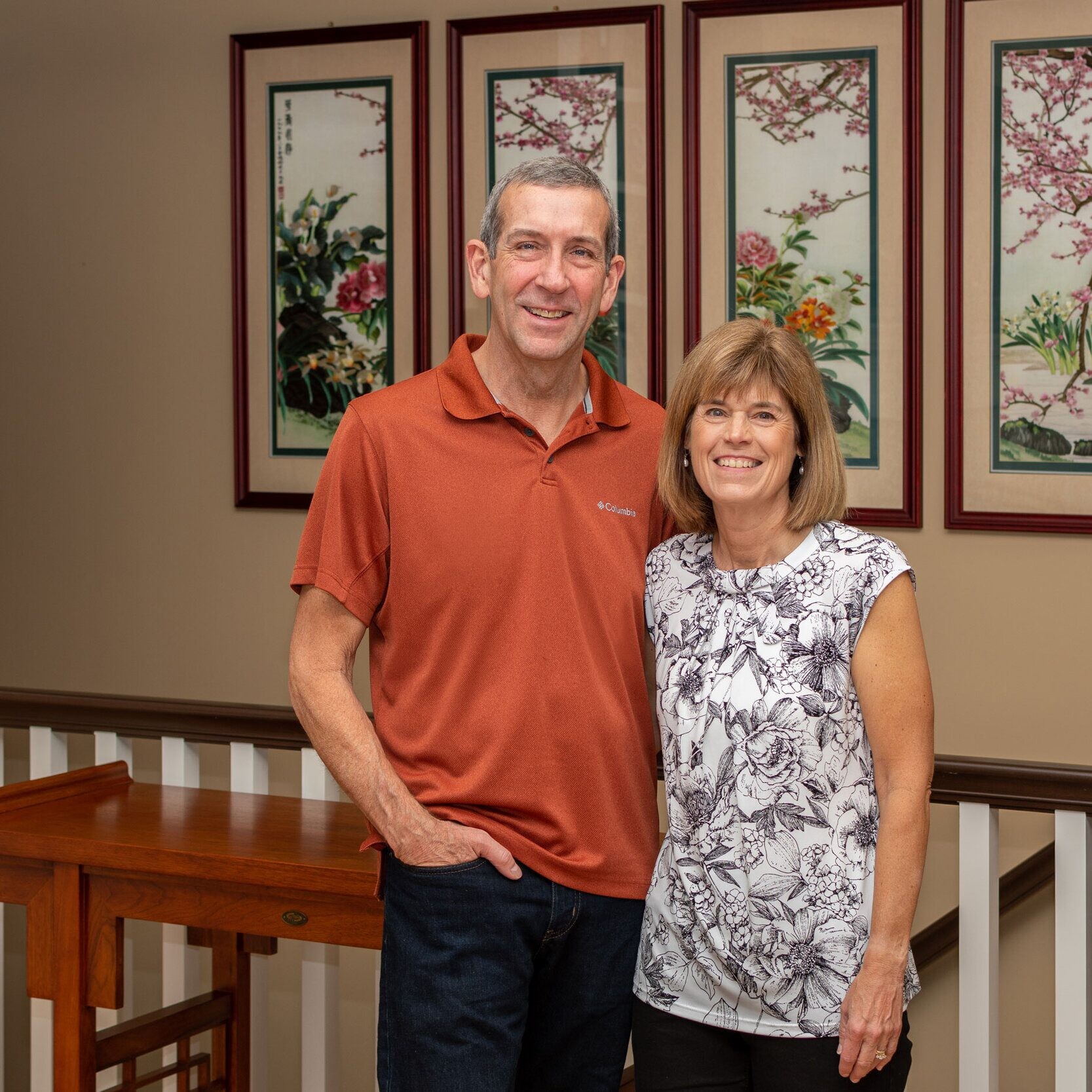 A man and woman standing in front of a staircase, showcasing a custom home built by a reputable Custom Home Builder in Indianapolis Indiana.