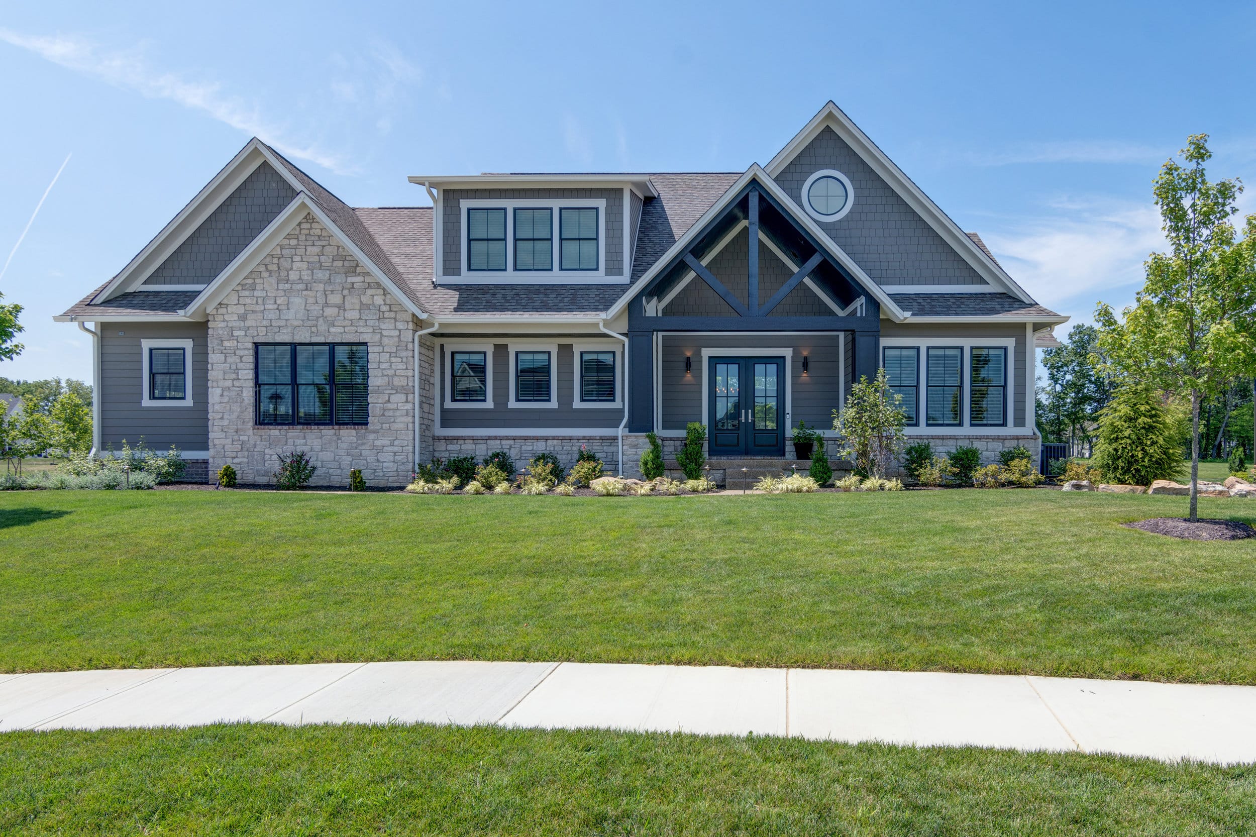 A custom home with a large front yard, built by a reputable custom home builder in Indiana.