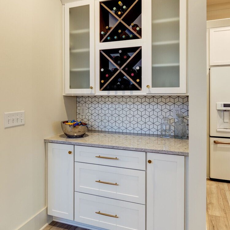 A kitchen with white cabinets, a wine rack, and custom home builder carmel indiana.