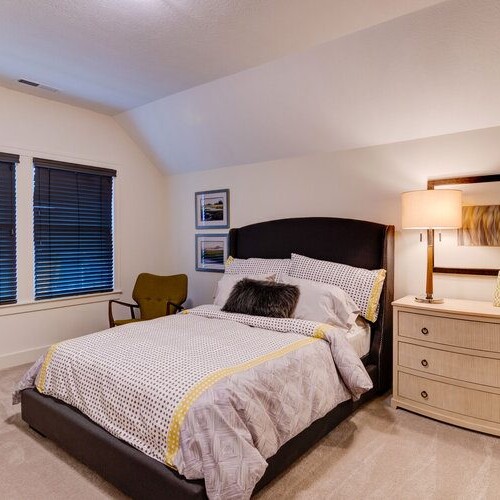 A bedroom with a bed and dresser in a new home construction.