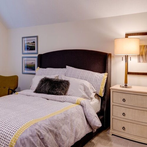 A bedroom with a bed and dresser in a new home construction.