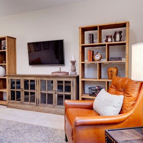 A living room with a tv and bookshelves in custom homes Westfield, Indiana.