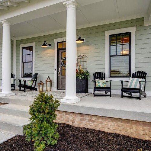 The front porch of a home with white pillars and chairs in Indianapolis, Indiana.