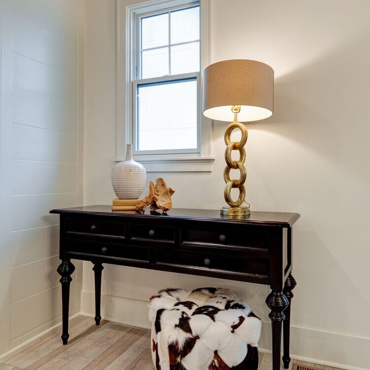 A black console table with a custom cowhide ottoman.