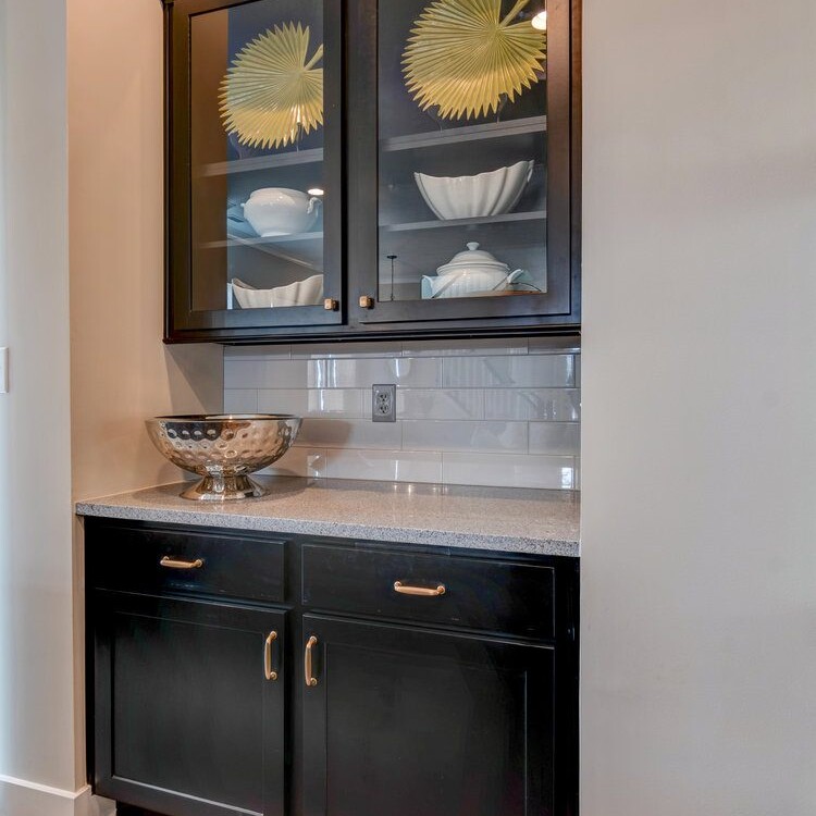 A kitchen with black cabinets and a bowl on the counter.