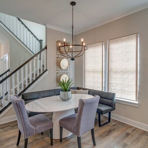 A dining room with hardwood floors and a staircase.