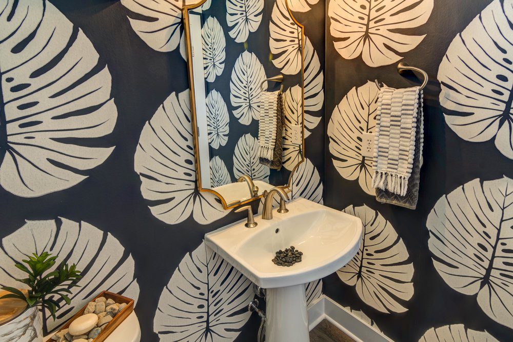 A black and white bathroom with a palm leaf wallpaper, located in Carmel, Indiana.