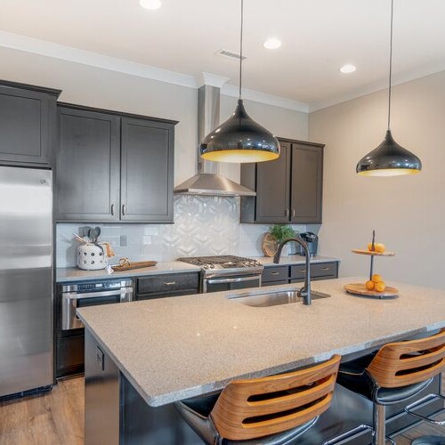 A kitchen with stainless steel appliances and gray cabinets.