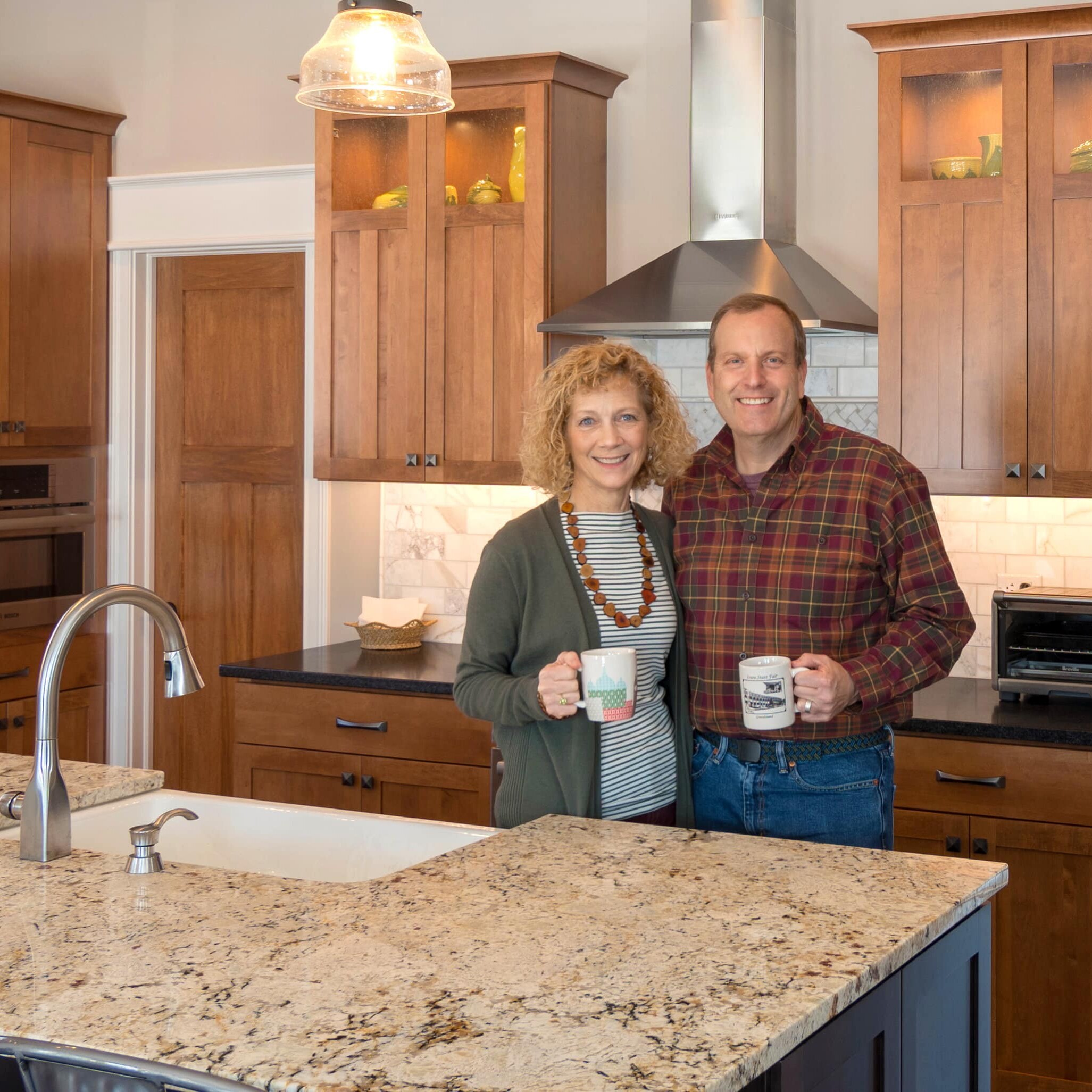 A man and woman standing in a kitchen, discussing their dream custom home build in Carmel, Indiana.