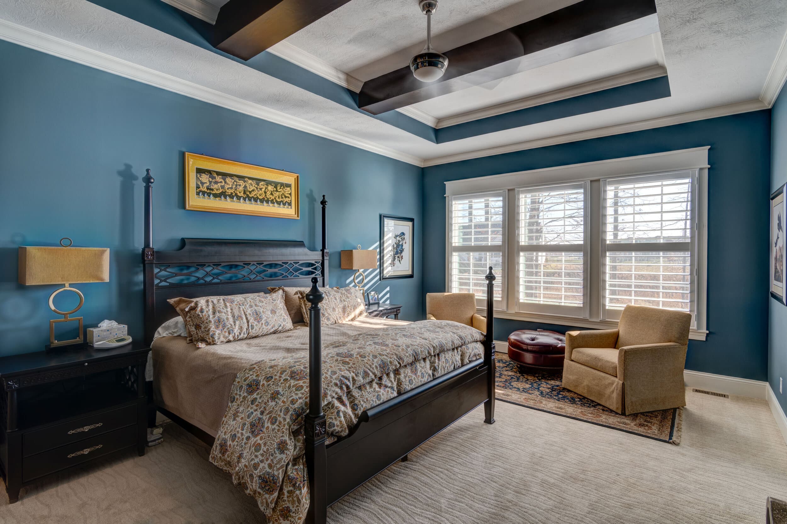 A bedroom with blue walls and a bed, built by a Custom Home Builder Fishers Indiana.