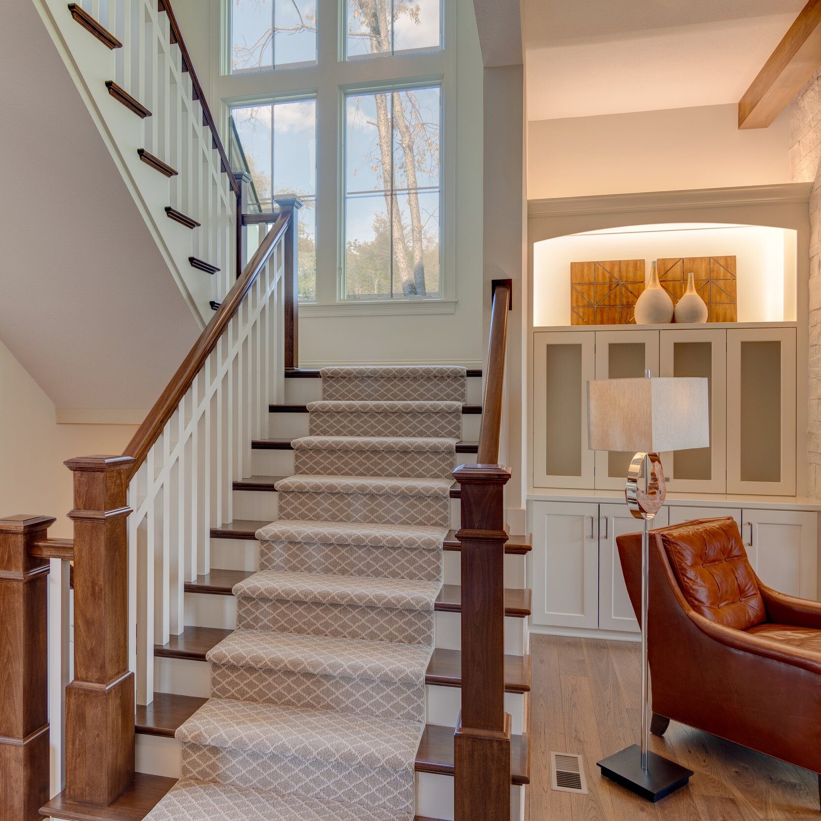 A new home construction in Indianapolis Indiana featuring a staircase leading to a living room with a fireplace.