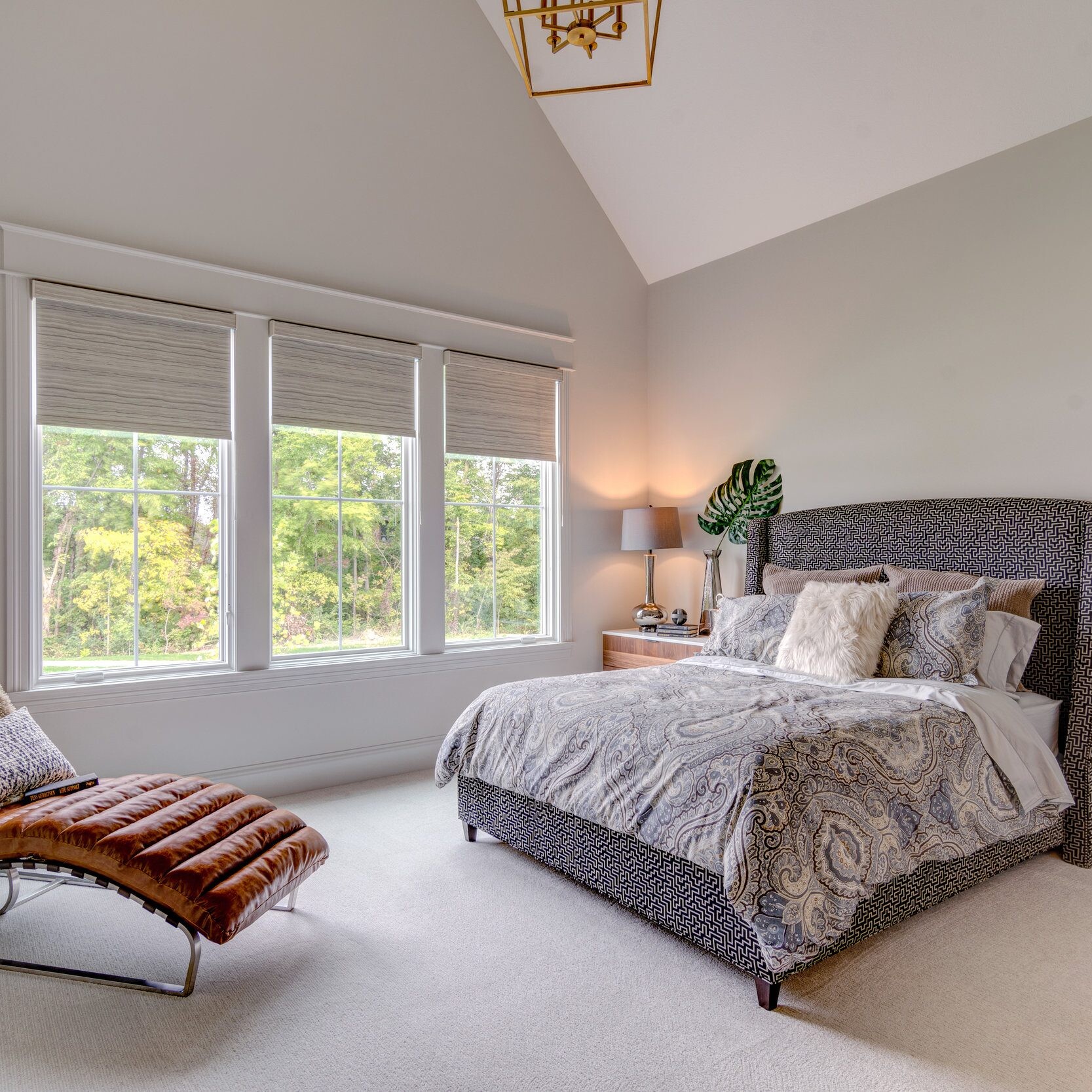 A bedroom with a bed and a chair in a new home construction.