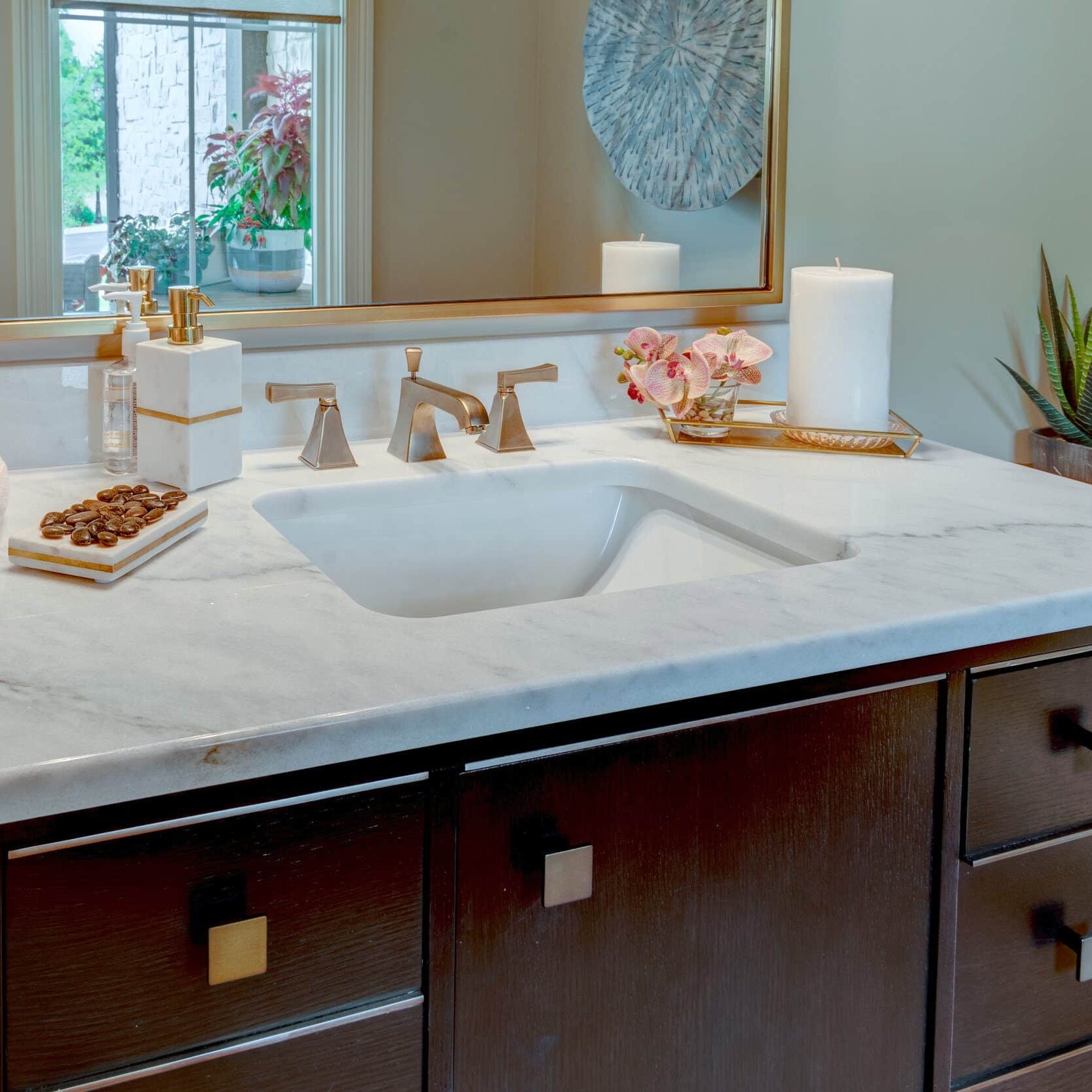 A bathroom with a marble sink and a mirror, built by a custom home builder in Carmel, Indiana.