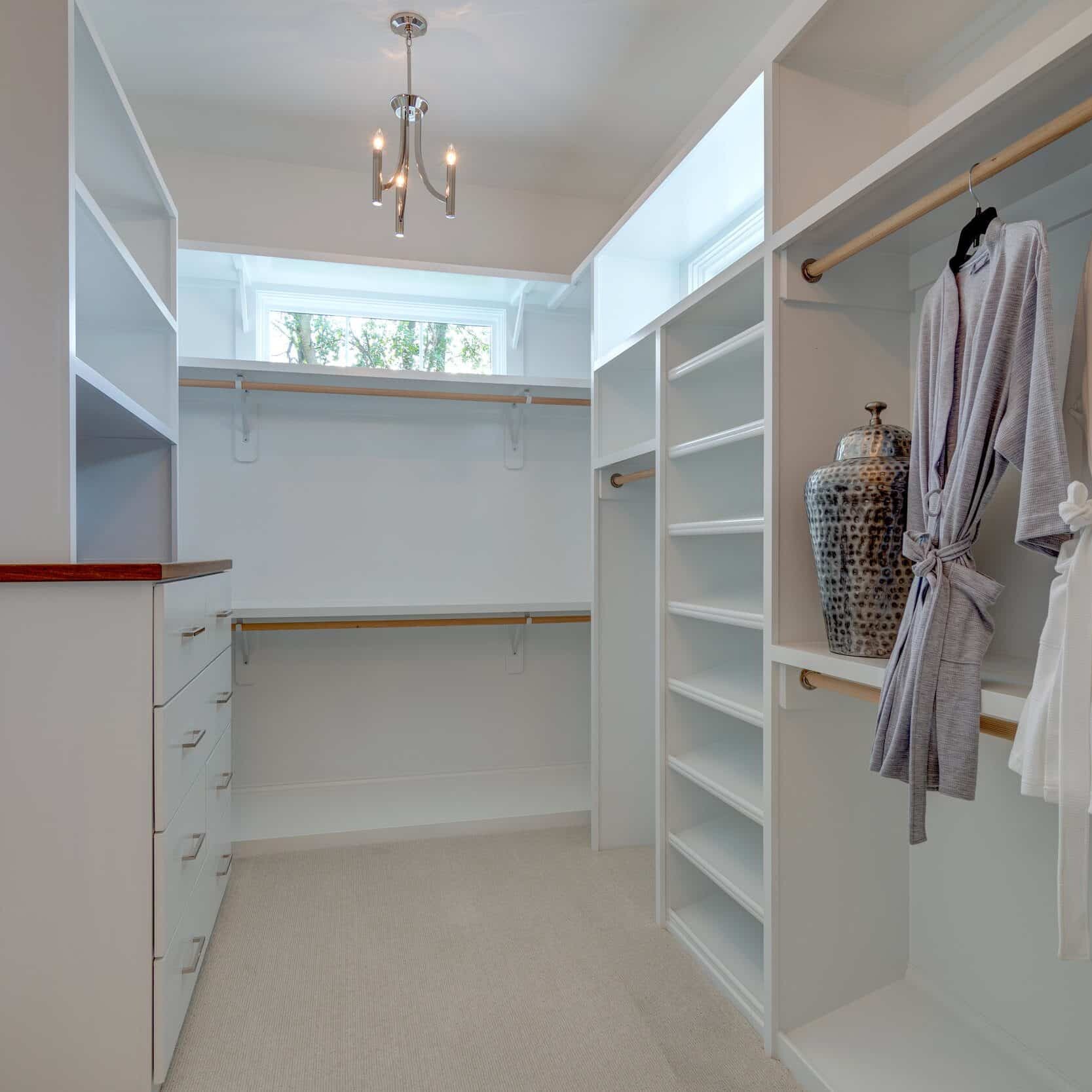 A white walk in closet with robes and towels in a custom home builder carmel indiana.