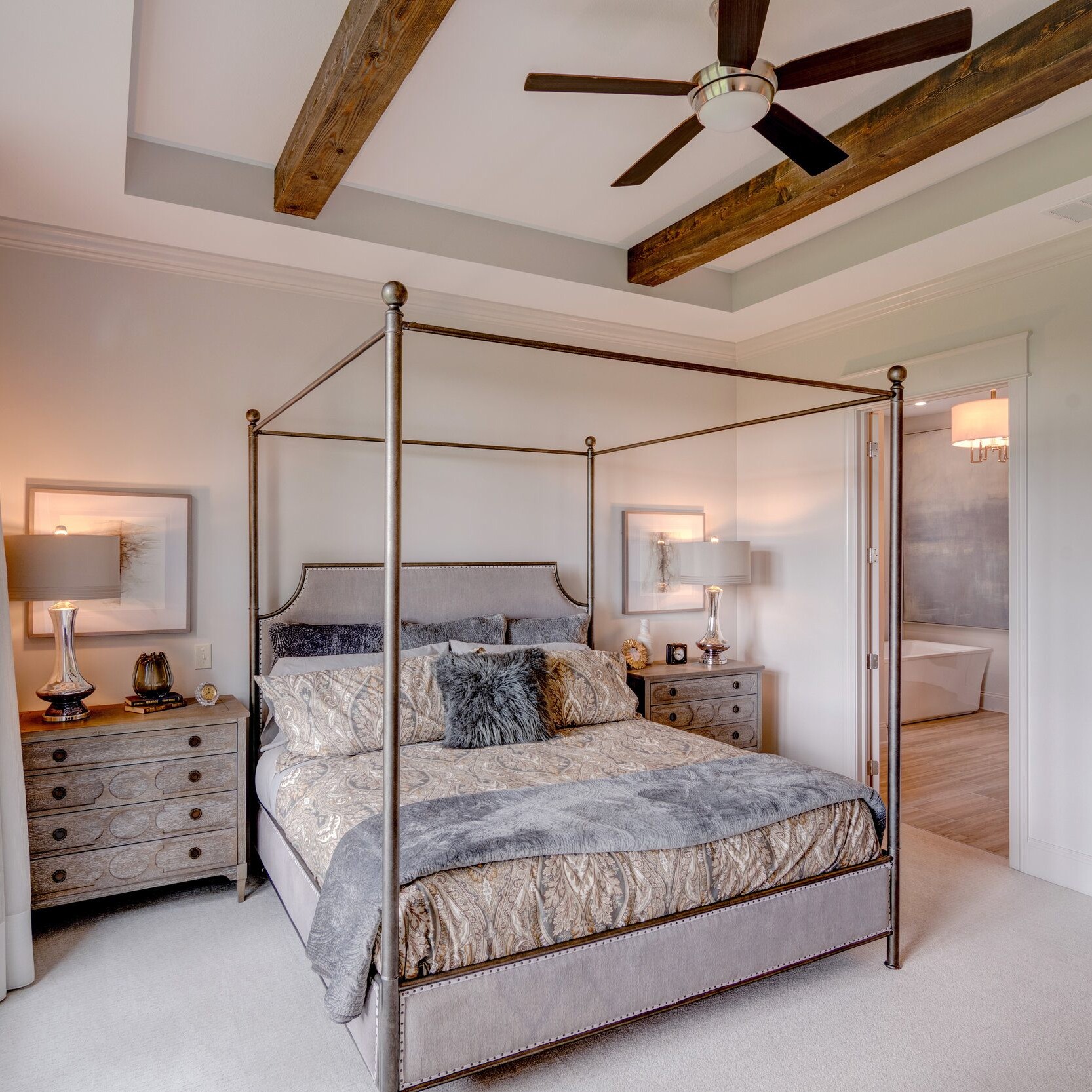 A four poster bed in a bedroom with a ceiling fan, located in Carmel, Indiana.