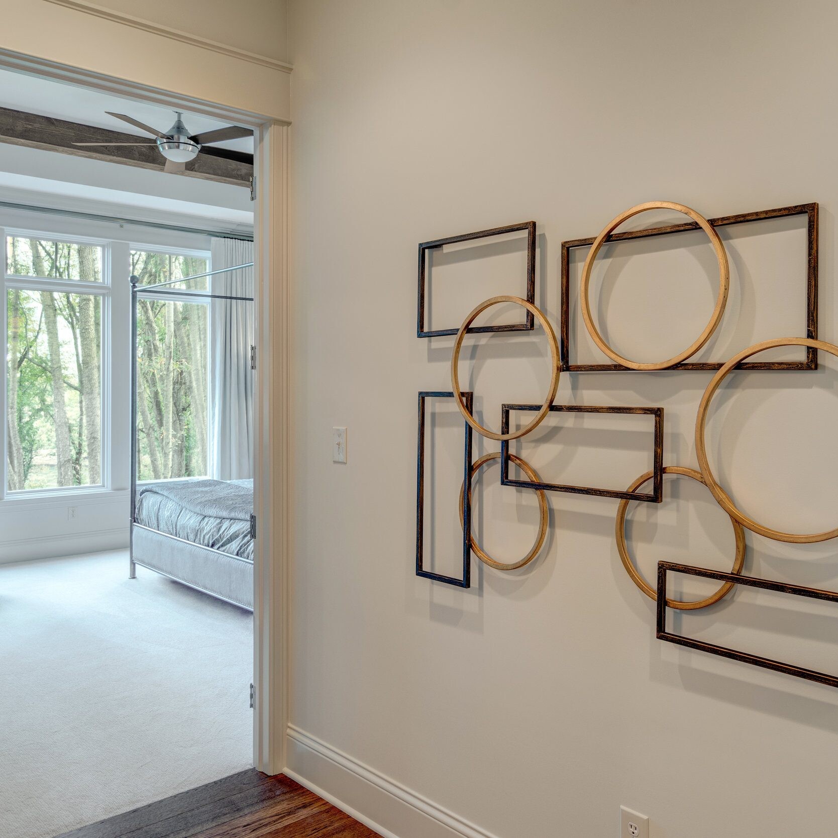 A bedroom with a large wall art and a bed in a new home construction.