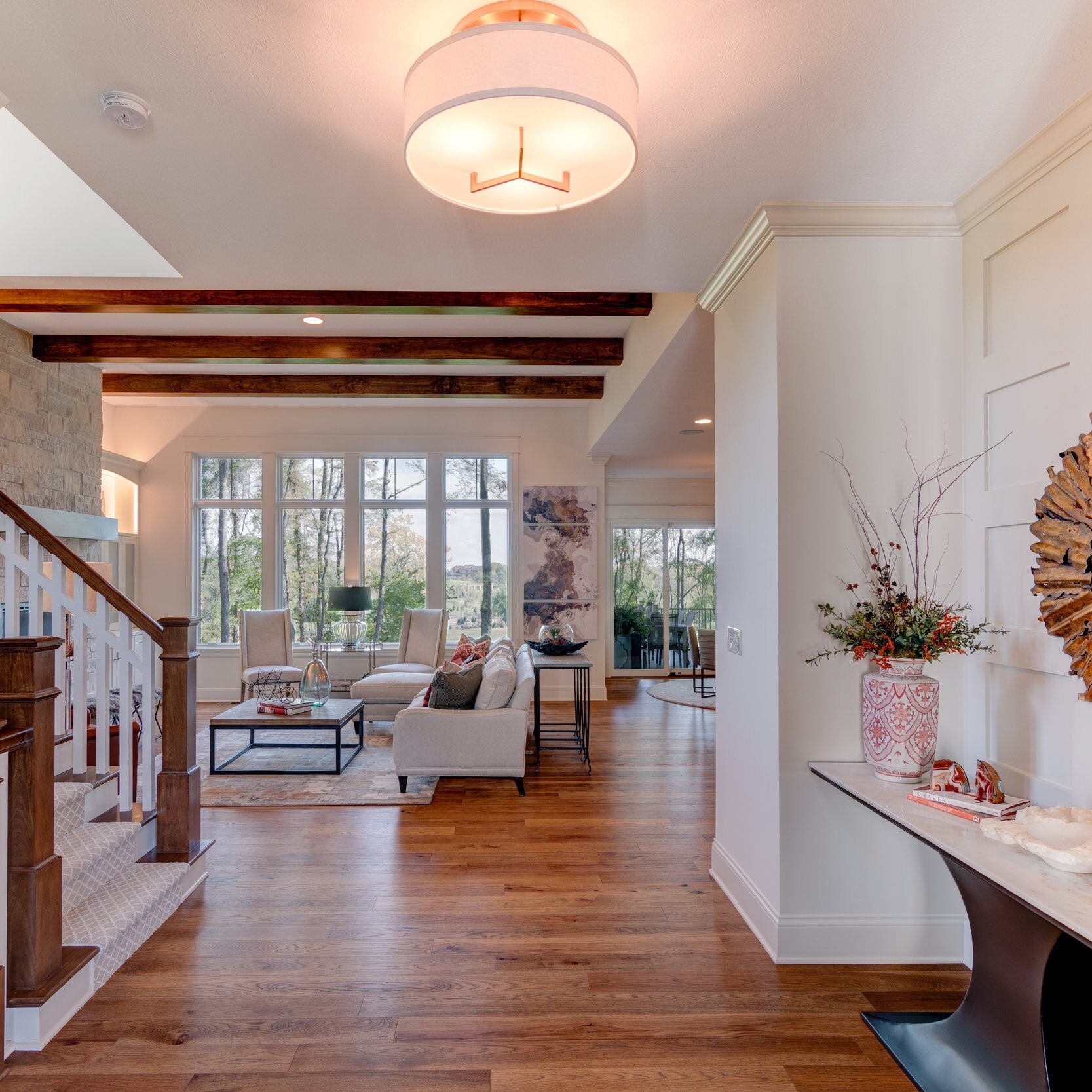 A newly constructed home in Indianapolis, Indiana displaying a beautiful hardwood-floor hallway leading to an elegant staircase.