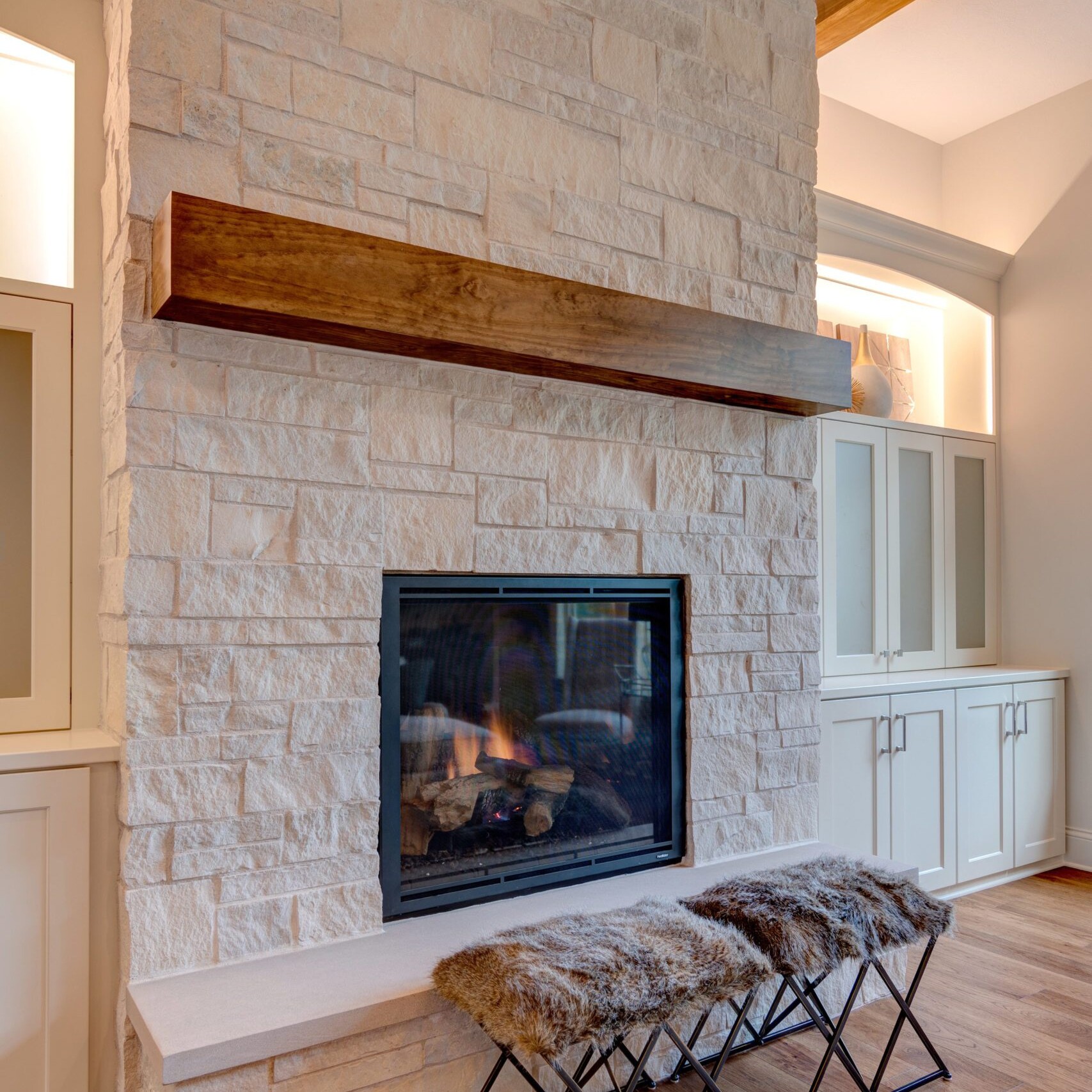 A living room with a stone fireplace and wooden beams available for new homes in Carmel, Indiana.