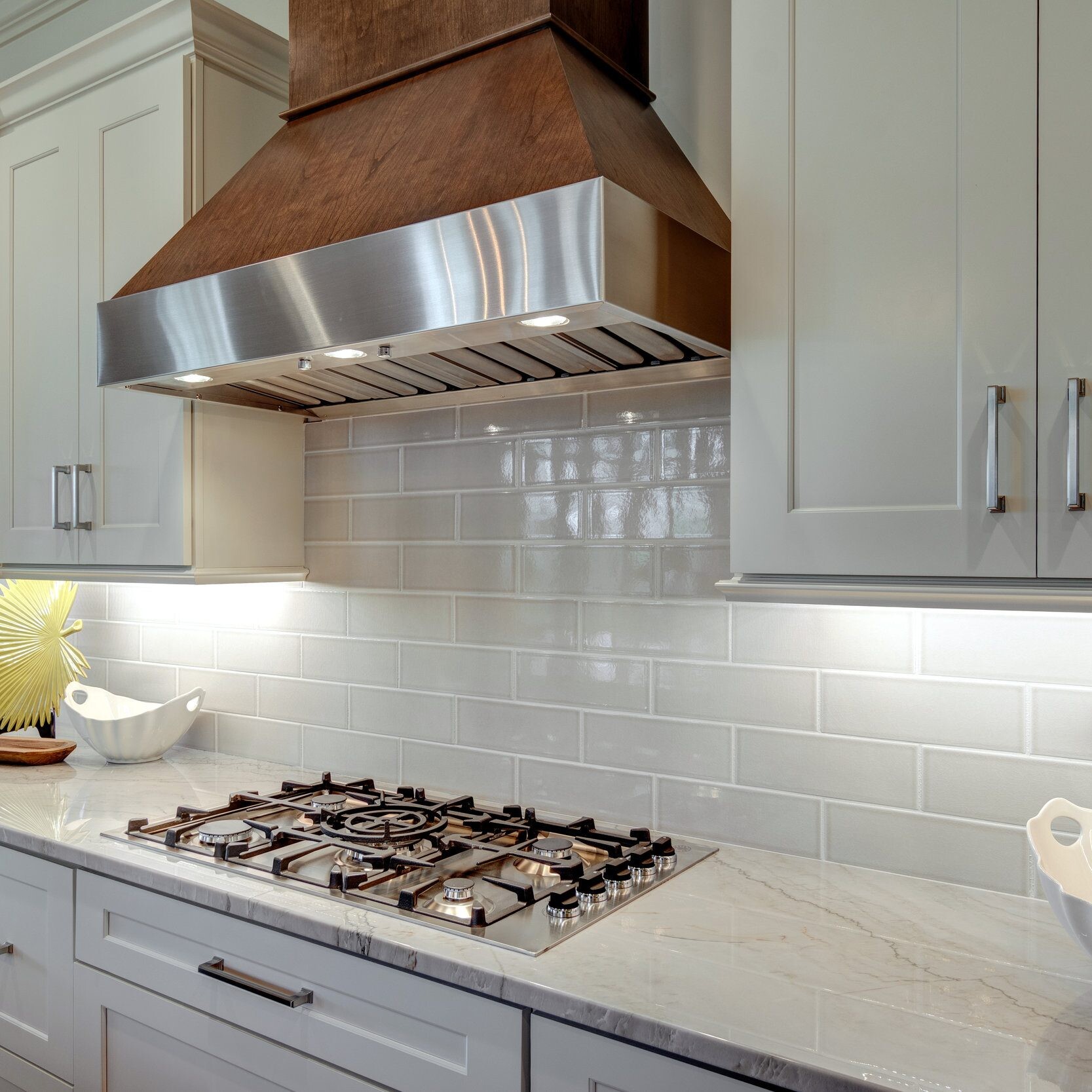 A kitchen with white cabinets and a stove hood in a new home construction in Indianapolis.