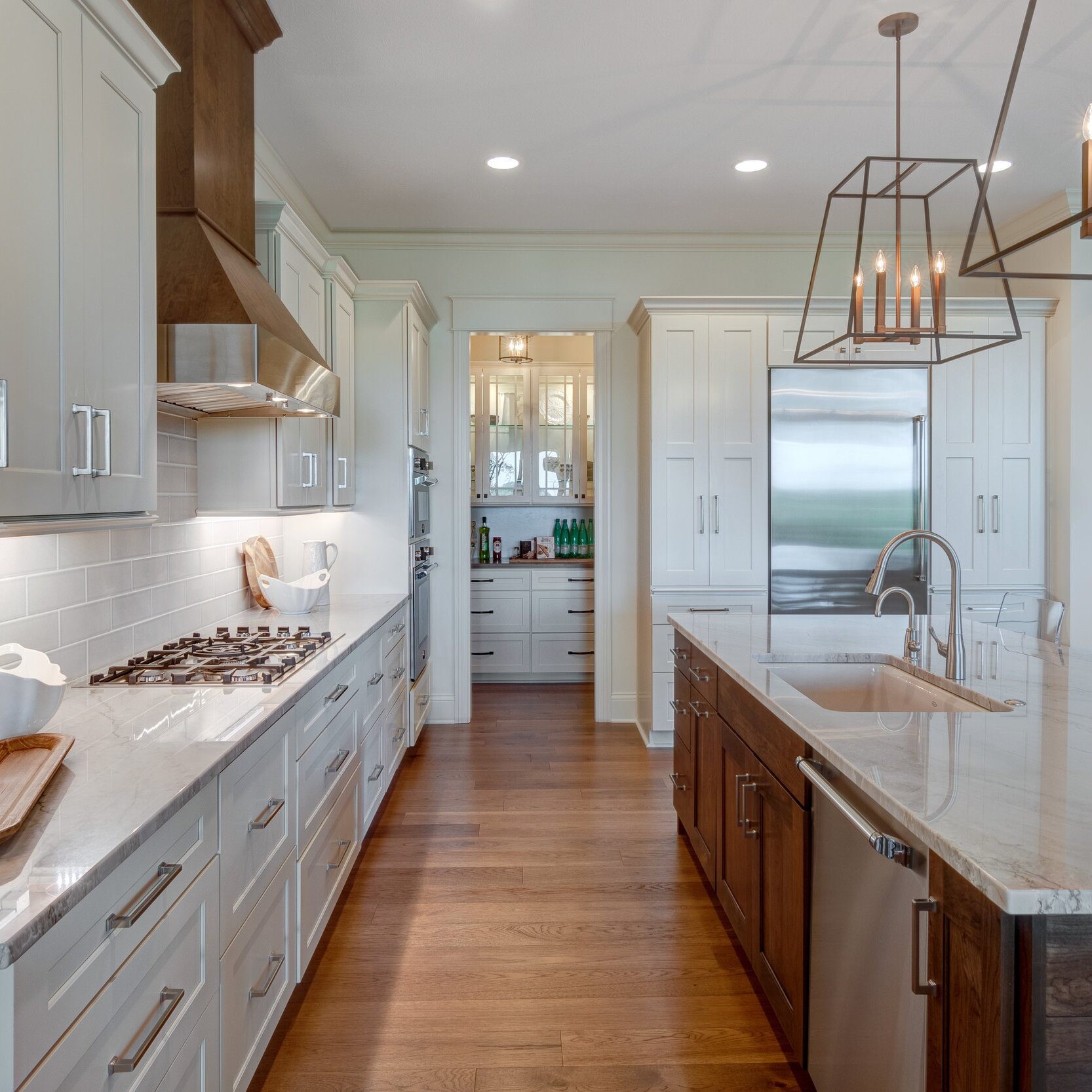 A new home construction in Indianapolis, Indiana featuring a custom kitchen with white cabinets and a center island.