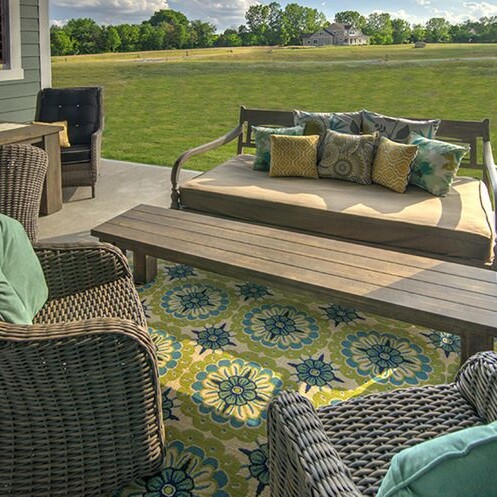 A luxurious patio with wicker furniture and a table, perfect for a custom home in Westfield or Carmel, Indiana.