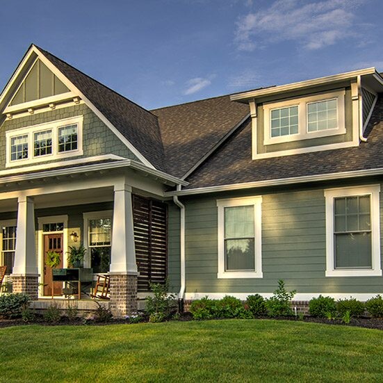 A custom home with a front porch and a green lawn, located in Indianapolis or Fishers, Indiana.