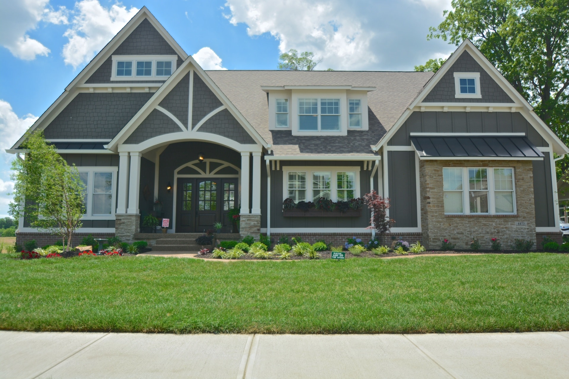 A luxurious home in Fishers, Indiana with a large front yard and a spacious front porch.
