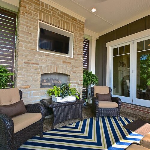 A patio with a fireplace and wicker furniture, perfect for enjoying the outdoors in your new home construction.