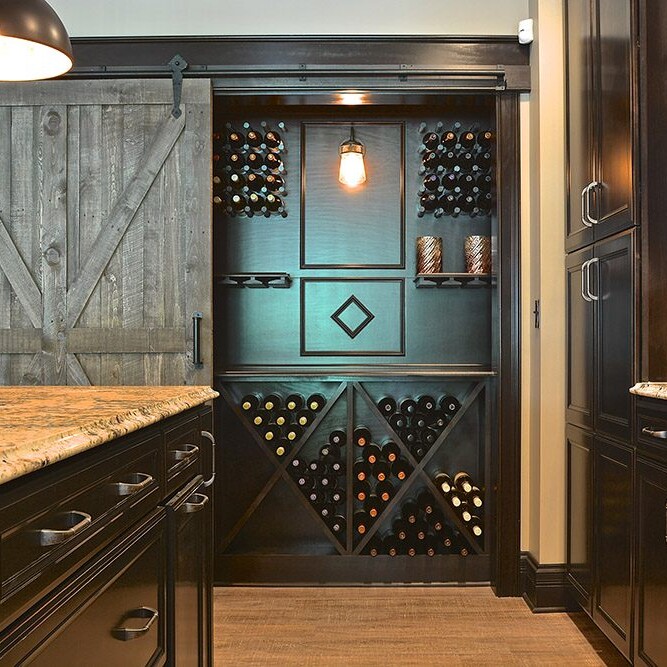 A kitchen with black cabinets and a wine rack in a custom home for sale in Carmel, Indiana.