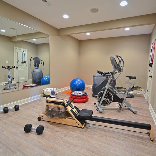 A custom home builder in Carmel Indiana offers new homes for sale in Carmel Indiana and Westfield Indiana. These custom homes are equipped with a home gym featuring exercise equipment and mirrors.