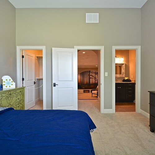 A bedroom with a bed, dresser and closet in a new home construction in Indianapolis, Indiana.