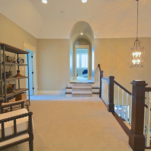 A hallway with a chair and bookshelf in a custom home in Westfield, Indiana.