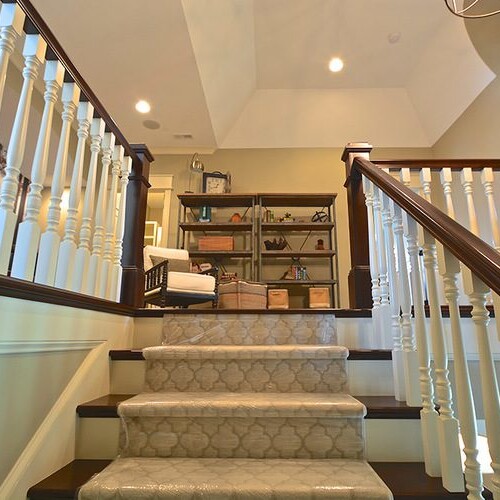 A custom home builder in Carmel, Indiana has recently completed new home construction in Indianapolis that includes a staircase with a white railing.