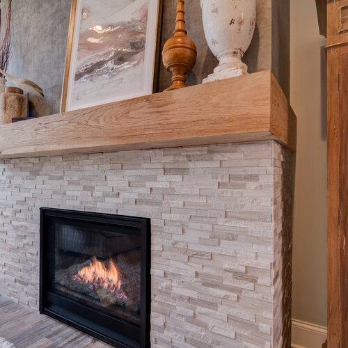 A stunning fireplace in a well-appointed living room with a beautiful wooden mantel.