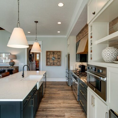 A kitchen with wood floors and a center island, perfect for custom homes in Westfield, Indiana.