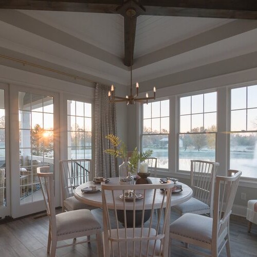 A dining room with large windows showcasing a picturesque view of a lake in Carmel, Indiana.