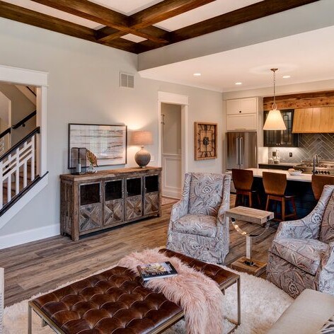 A stunning living room with beautiful hardwood floors and an elegant staircase.