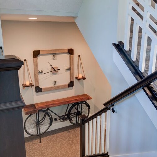 A stairway with a clock on it and a clock on the wall in a new home construction.