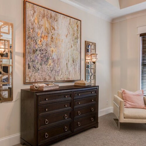 A new bedroom with a dresser and a large painting.