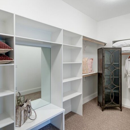A walk in closet with shelves and a dresser, perfect for new homes for sale in Carmel Indiana.