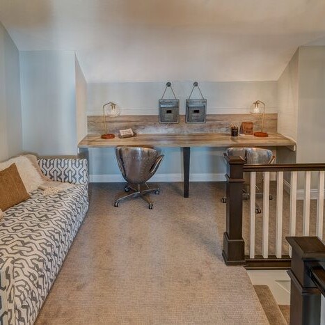 A living room with a couch and a stairway in a new home construction in Indianapolis, Indiana.