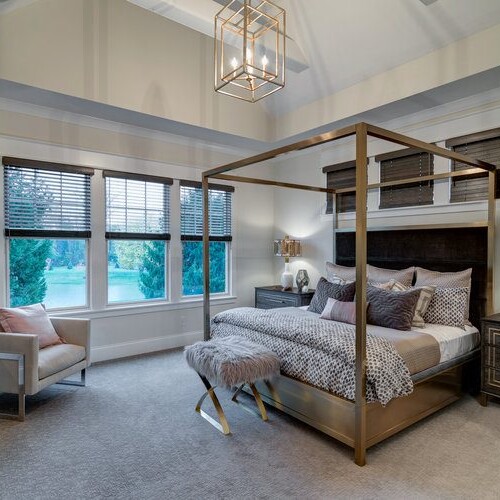 A four poster bed and a chandelier elegantly adorn this bedroom in our new home construction in Indianapolis, Indiana.