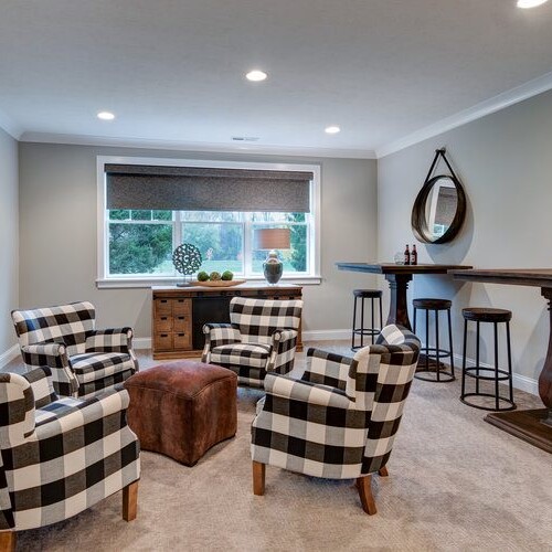 A living room with chairs and a mirror available in custom homes for sale in Carmel, Indiana.