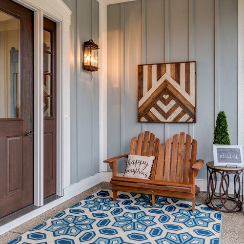 A front porch with a wooden bench and blue rug, perfect for new homeowners in Indianapolis, Indiana.