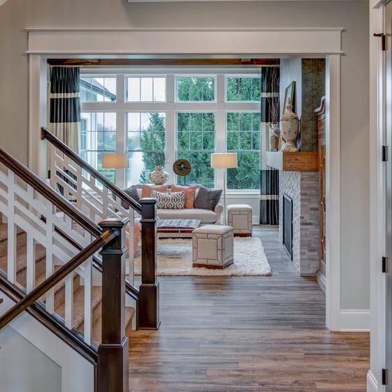 A new home construction with hardwood floors and a staircase leading to a living room.