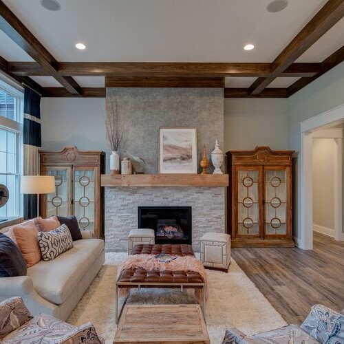 A cozy living room with hardwood floors and a fireplace, perfect for those seeking new home construction in Indianapolis or custom home builder Carmel Indiana areas.