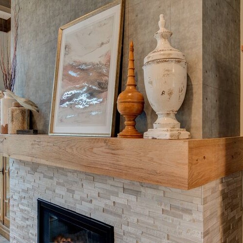 A cozy living room with a fireplace and wooden mantle.