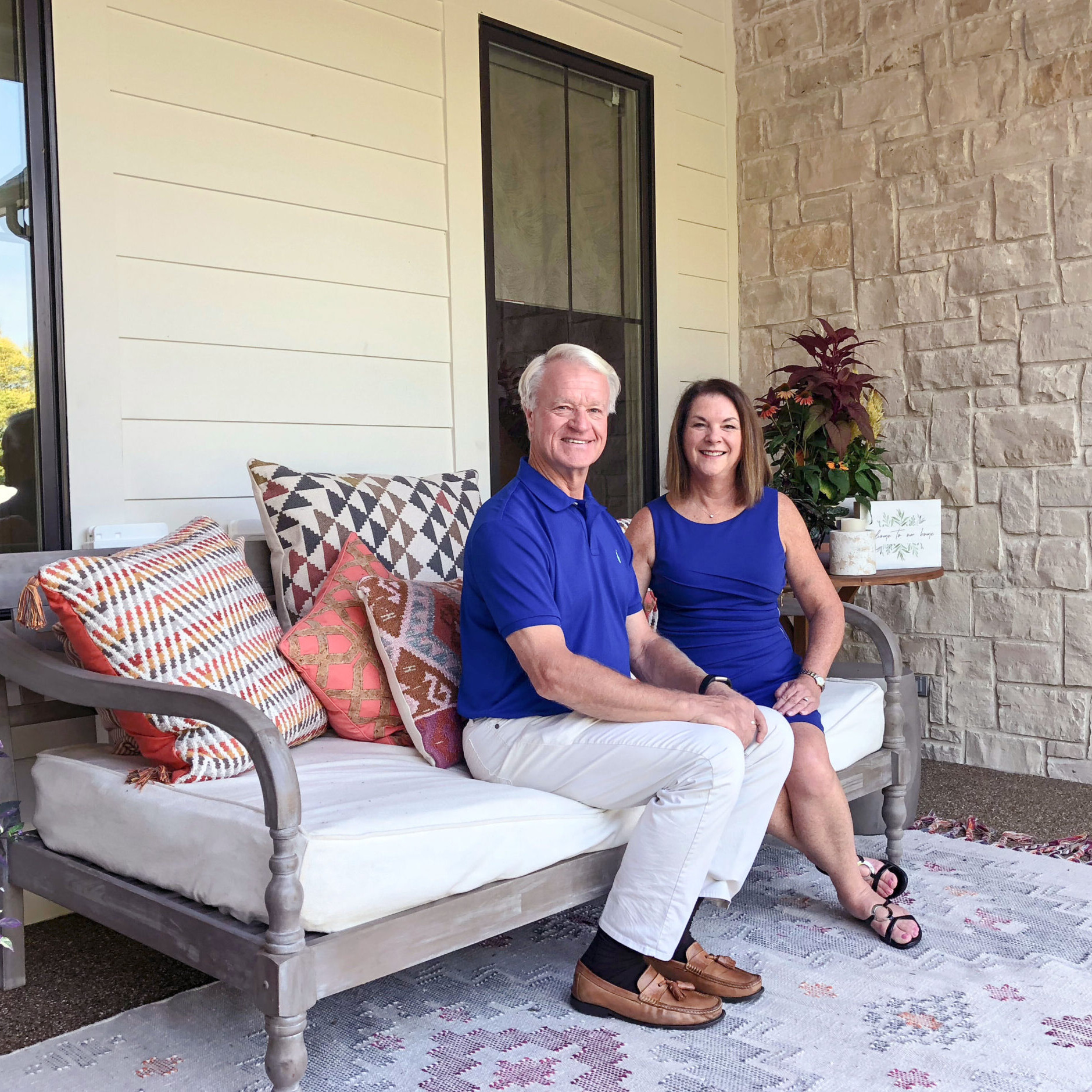 A man and woman sitting on a porch of their new custom home near Indianapolis, built by a top-rated custom home builder in Fishers, Indiana.